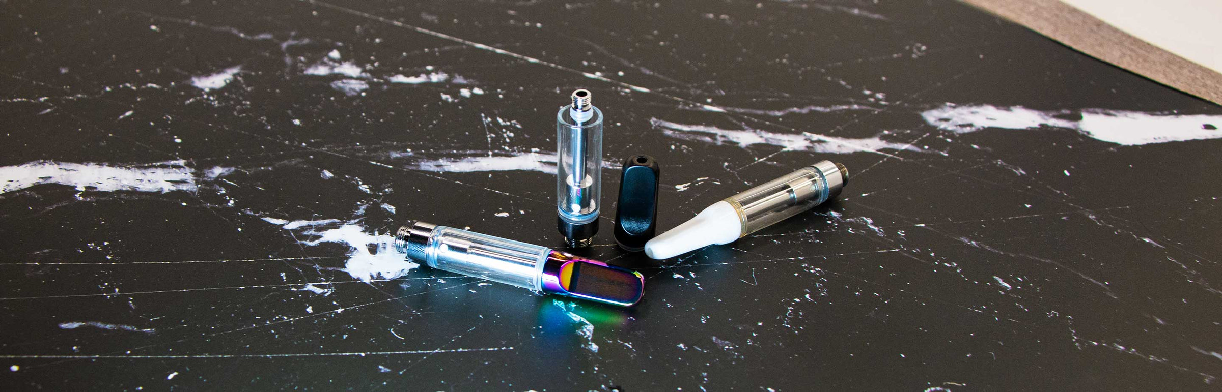 Wholesale Vape Cartridges laying down on black and white marble texture table in studio